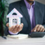Man_holding_small_house