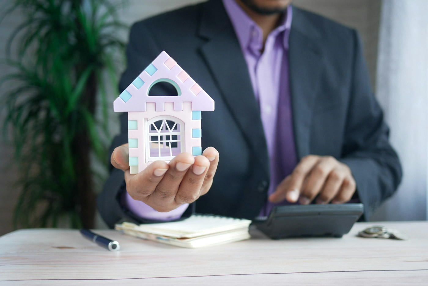 Man_holding_small_house
